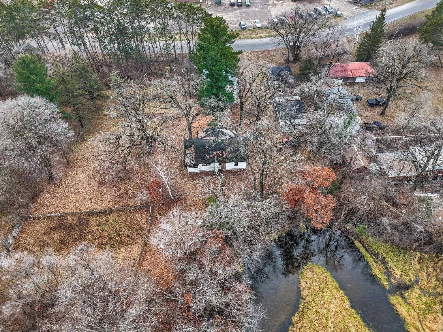 House in center of photo, pole barn between house and street, garage and shop off to the right.