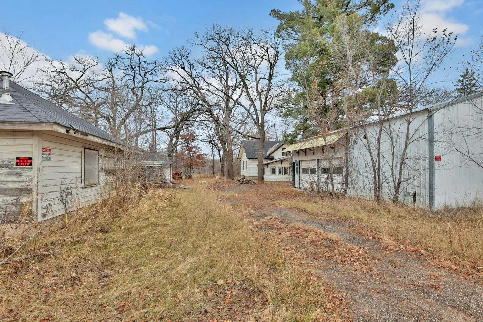 Driveway up to the house.  Pole barn to the left, wood shop to the left.  2 car garage to the north of shop.