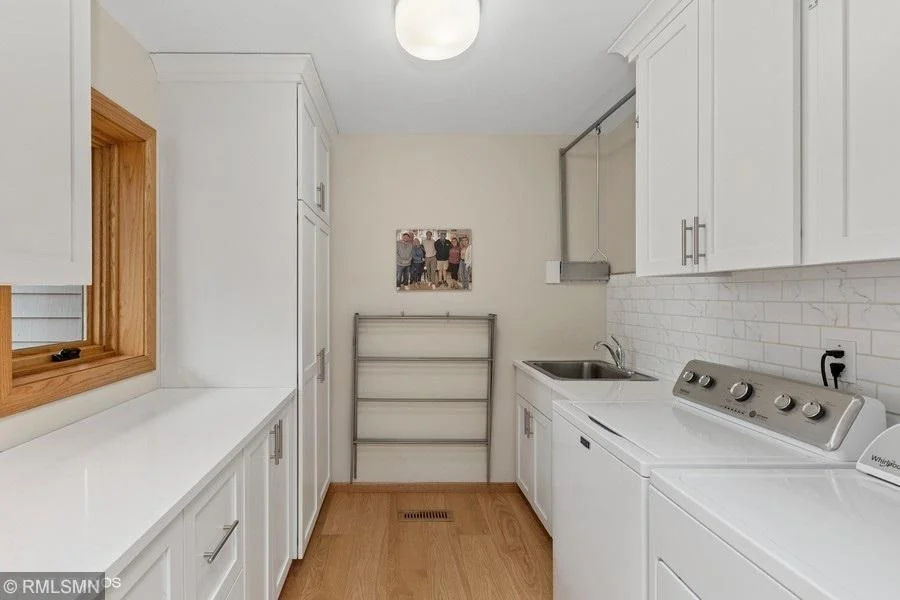 Amazing laundry room right off the kitchen!  Plenty of cabinets and a great folding counter and drying bar!