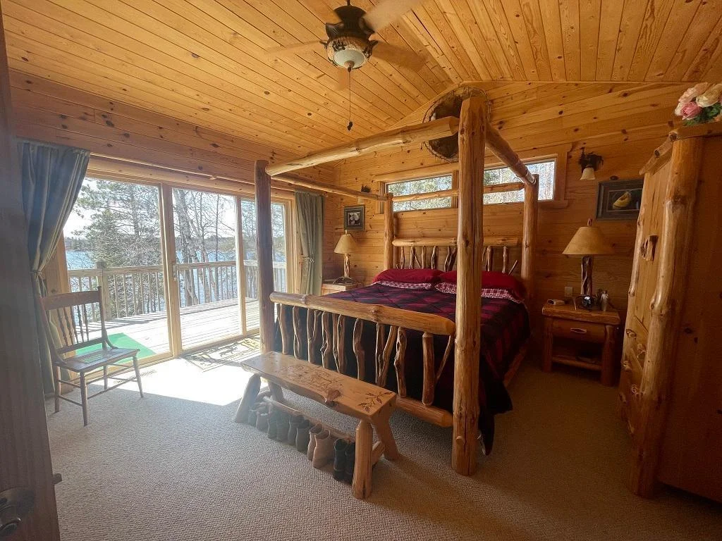 Main level primary bedroom with patio doors to deck.