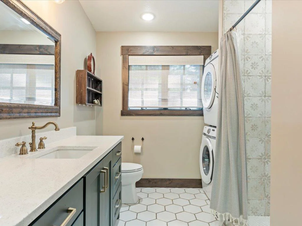 Large bathroom with quartz countertops, tile floors, and laundry.