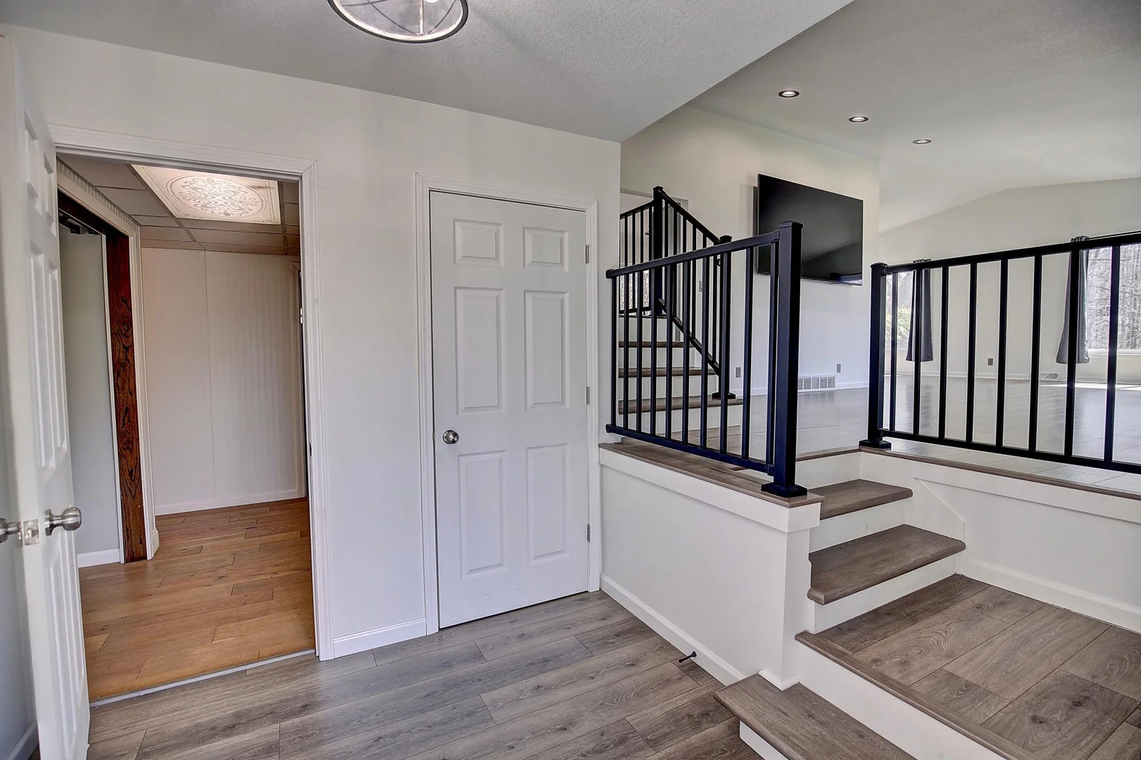 Foyer with updated flooring & railing system. A very open & clean feel when walking in the front door.