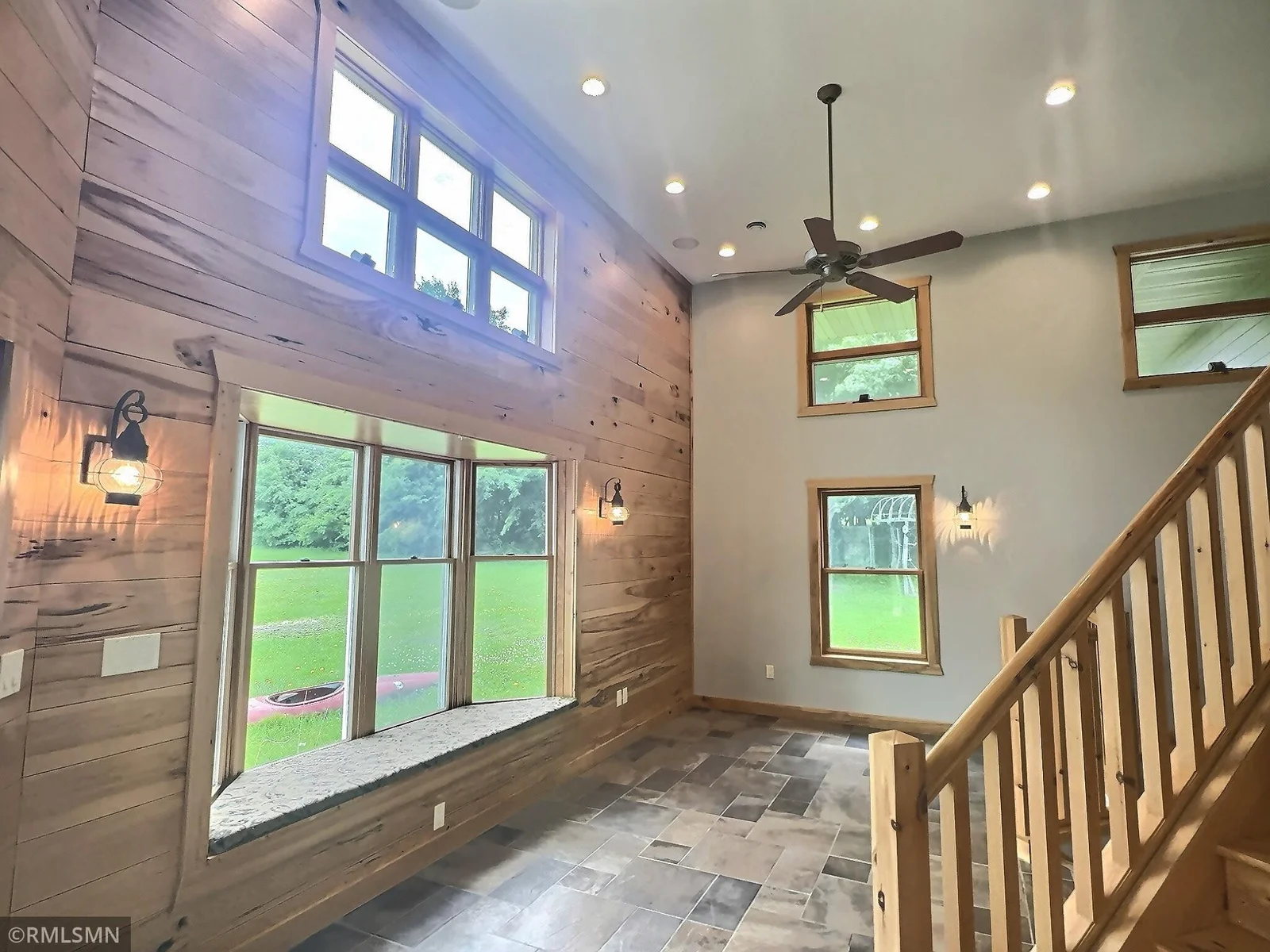 This massive foyer/sunroom welcomes you with heated stone stile flooring, high ceiling and rustic hickory accents and tongue and groove walls.