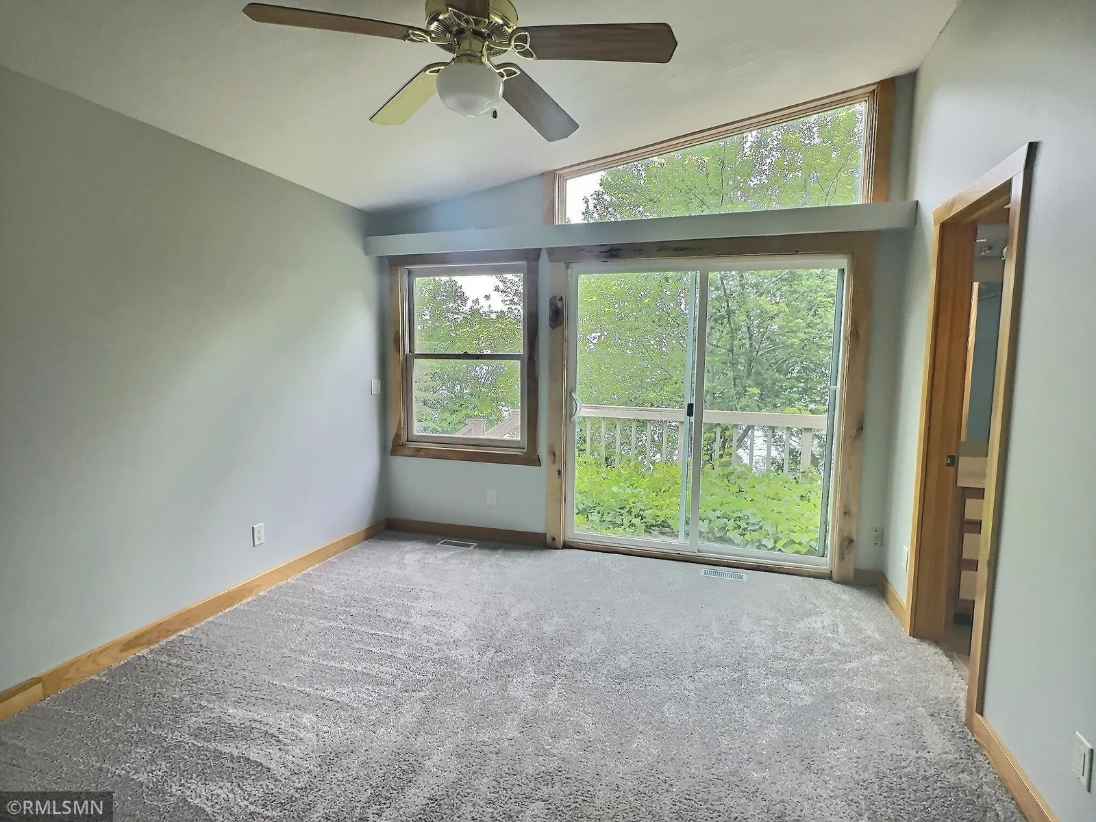 The primary suite features a stunning wall of lakeside windows and a vaulted ceiling, complemented by fresh paint and new carpeting.