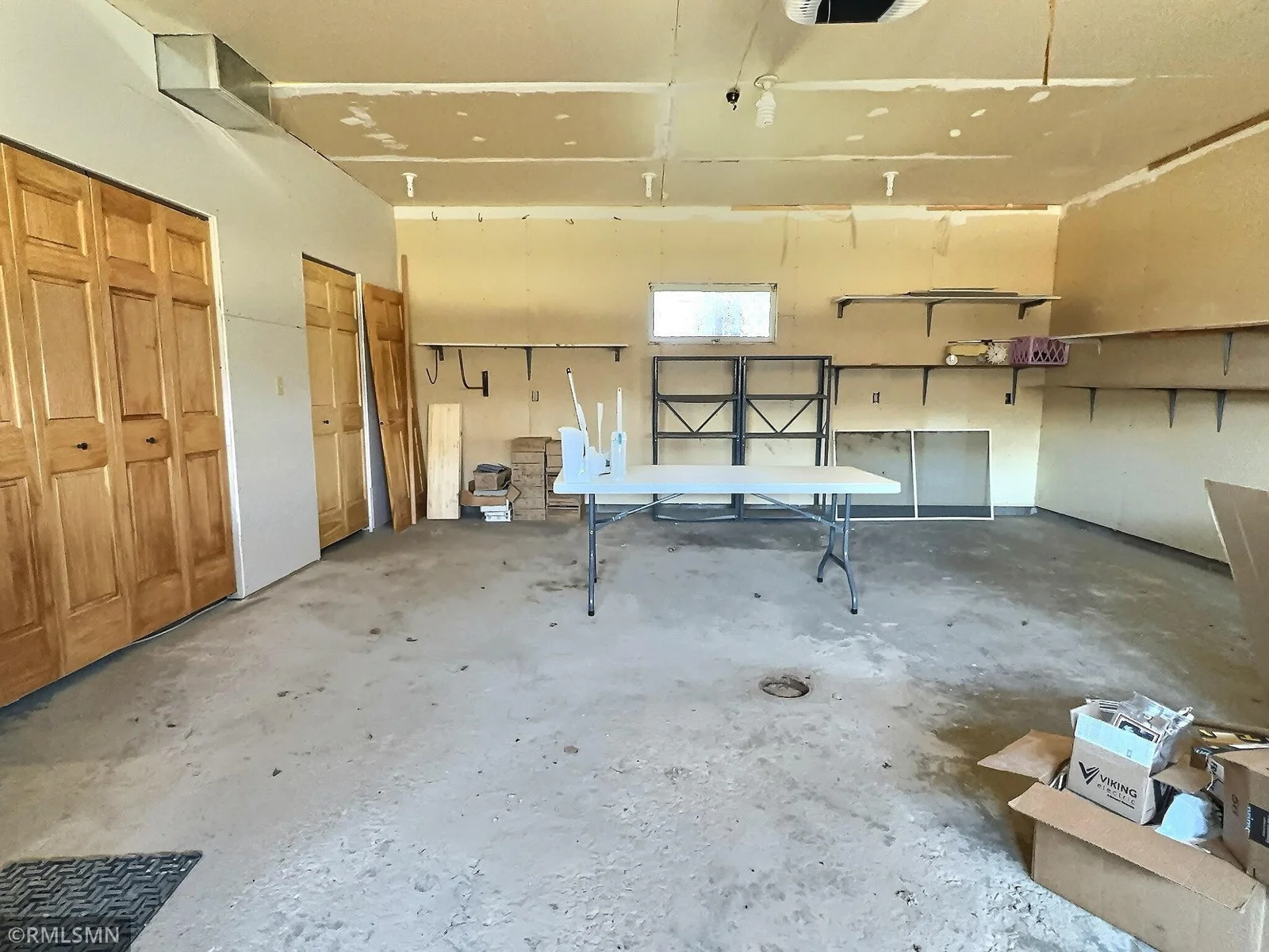 Two car attached garage with additional closets for more storage and shelving.