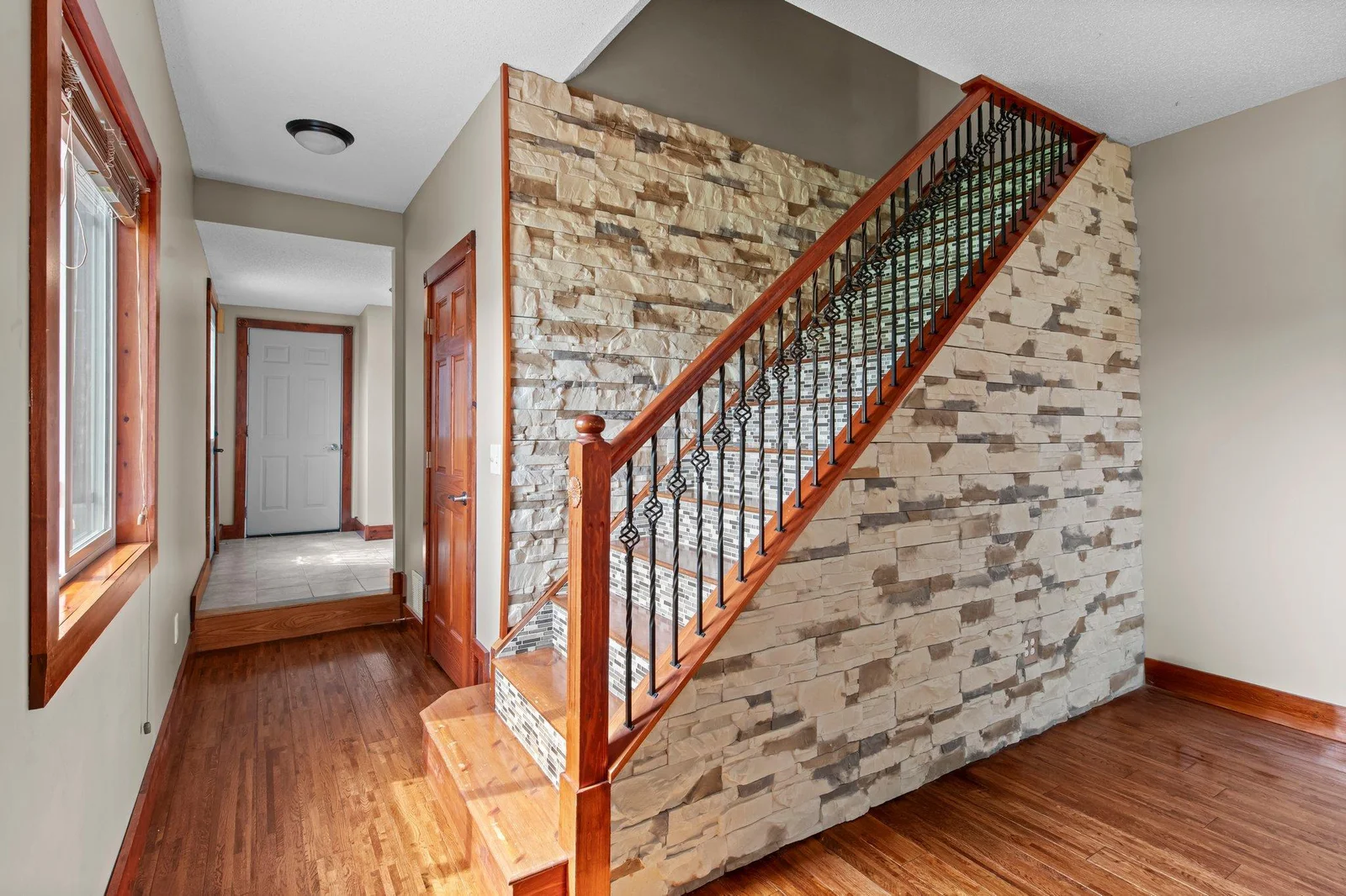 The staircase to the upper level includes beautiful stone and mosaic tile.