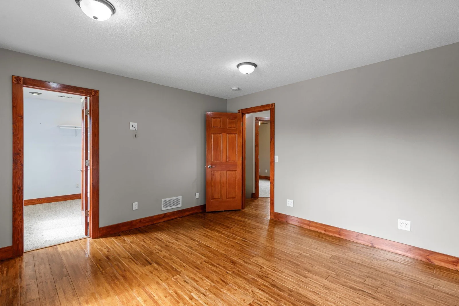 The primary bedroom on the upper level includes hardwood floors and a large walk-in closet.