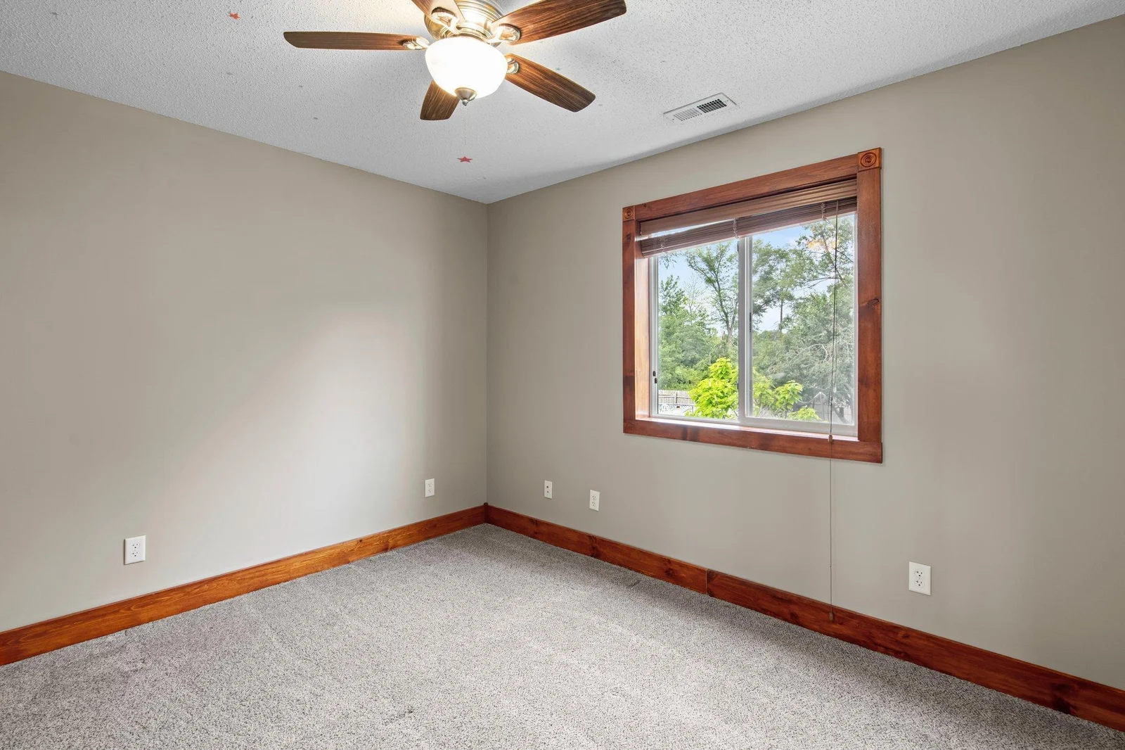 The second bedroom on the upper level includes a ceiling fan and gorgeous wooden trim.