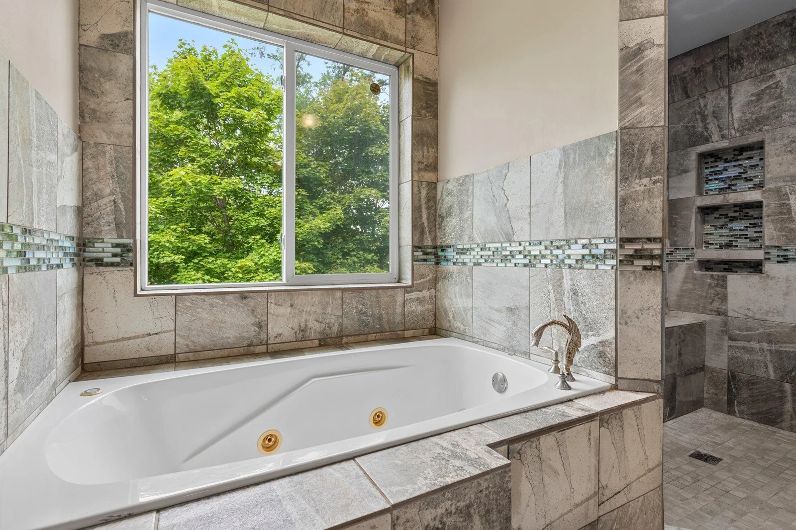 The upper level bathroom includes a spa-style walk-in shower and a separate jetted tub.