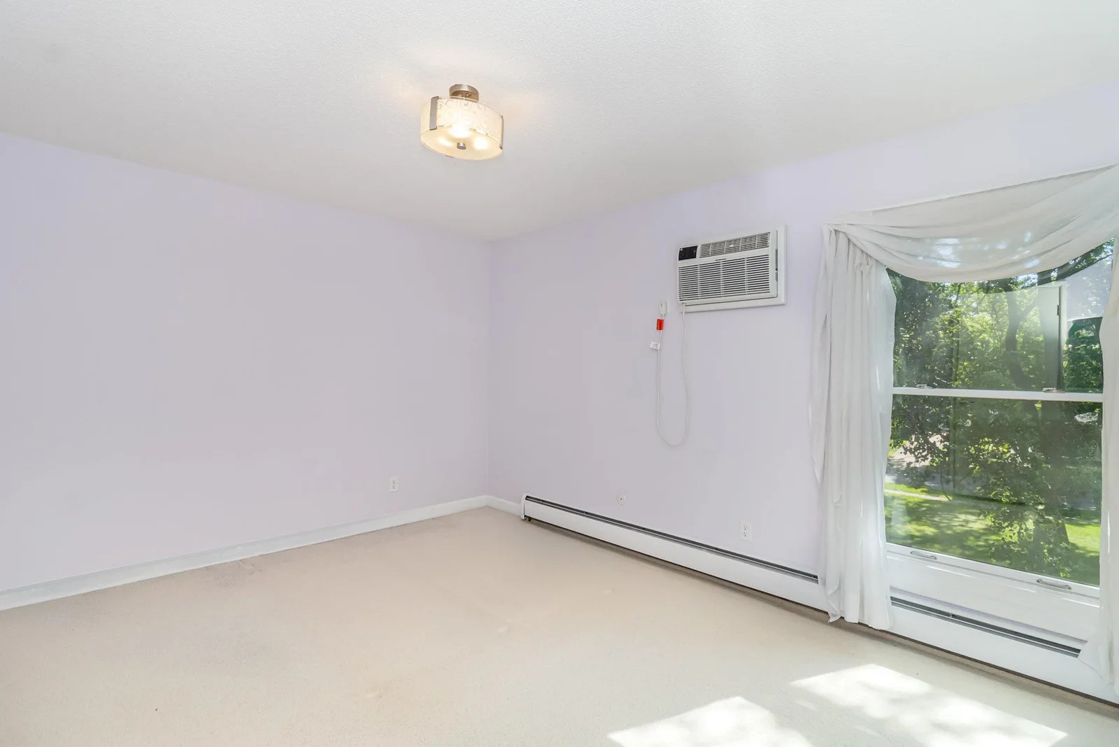 The primary bedroom has a beautiful outdoor view and includes a second wall-unit air conditioner.