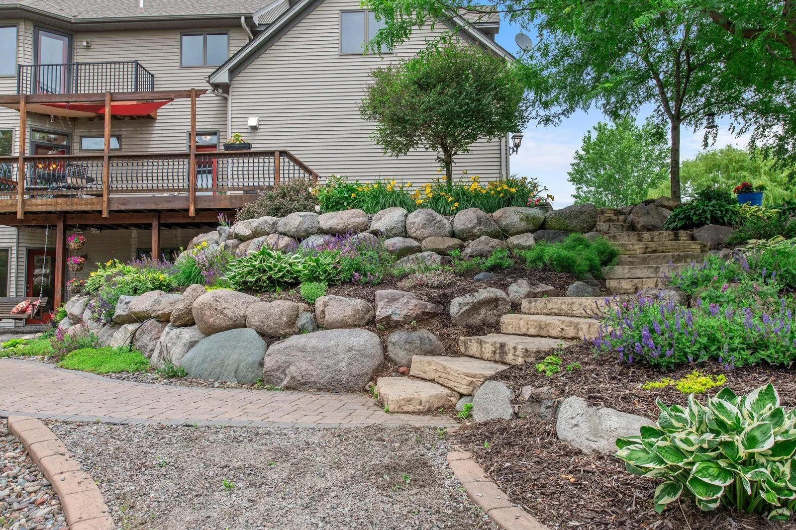 This expertly landscaped property includes a stone-step path to the pool area in the backyard.