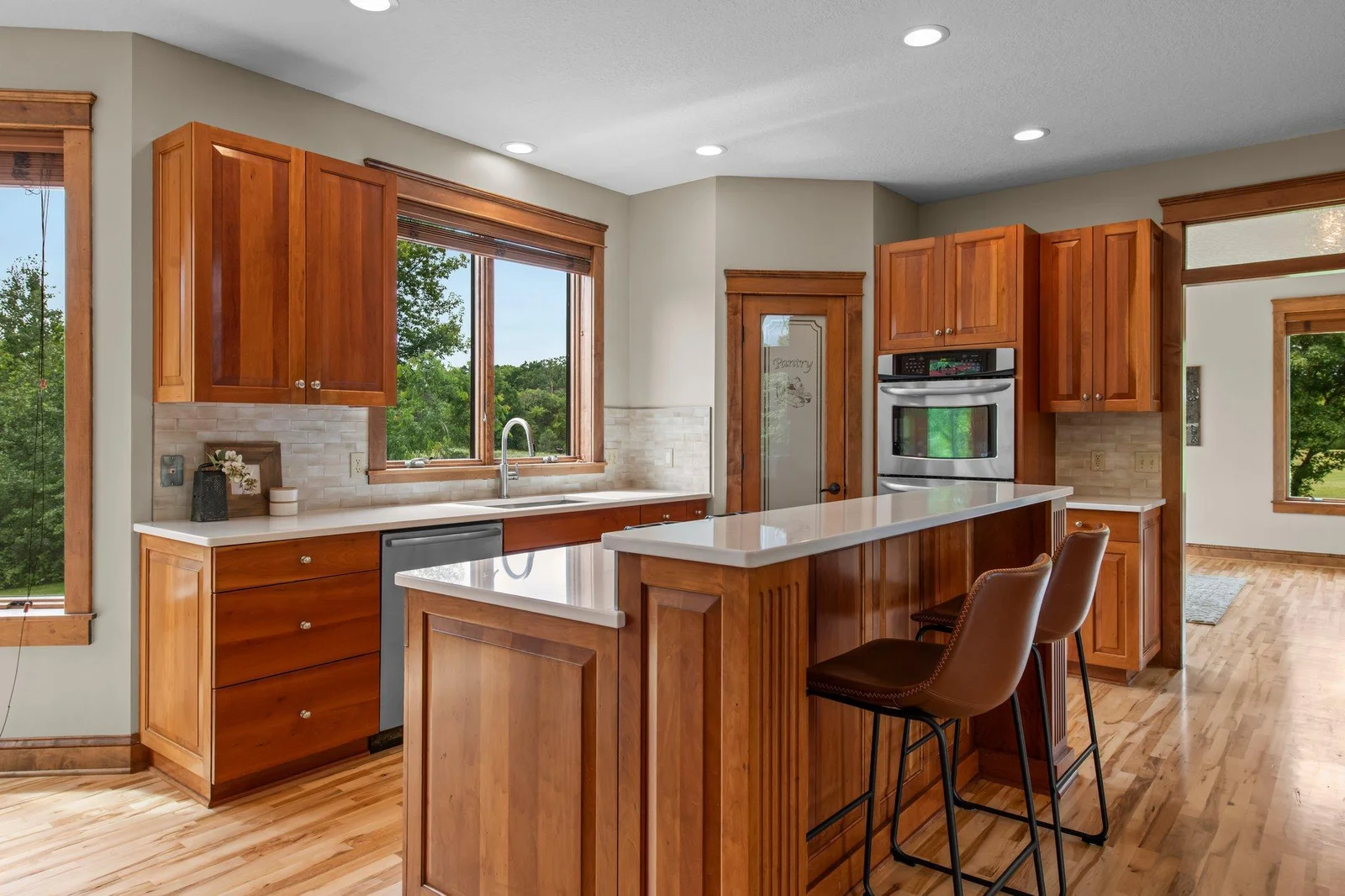 The gourmet kitchen includes custom cabinets, a double oven, cooktop and a stainless steel appliance package.