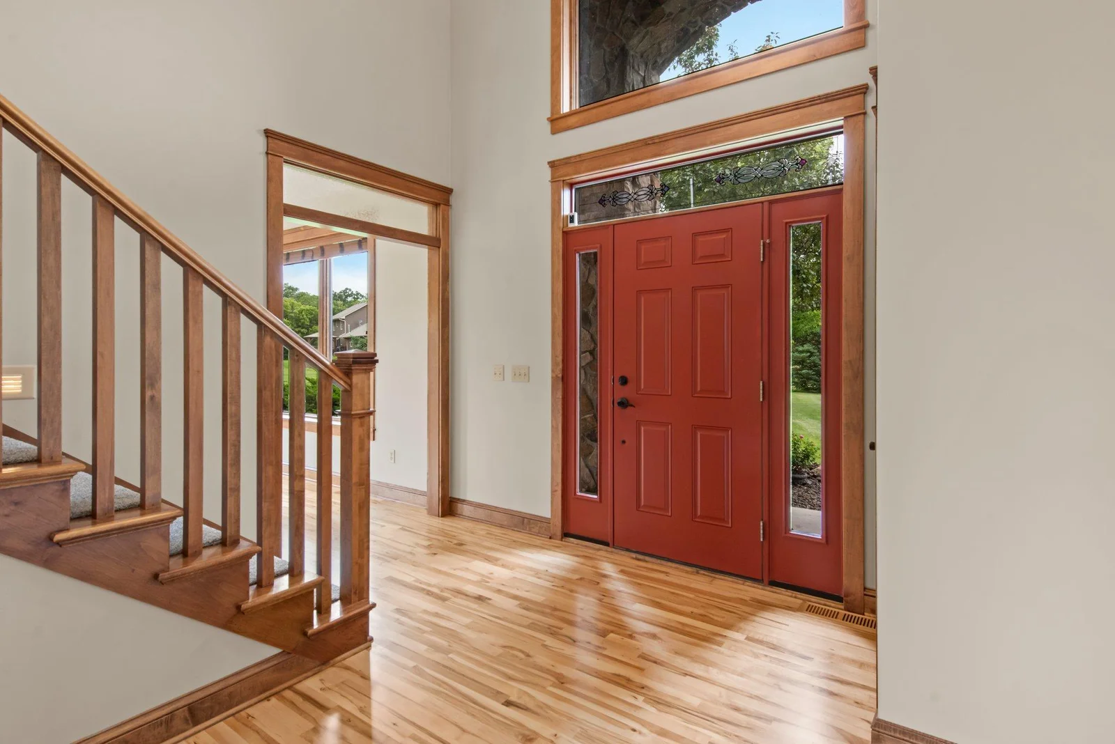 The entry includes sidelights and a large window above the door to let in natural light.