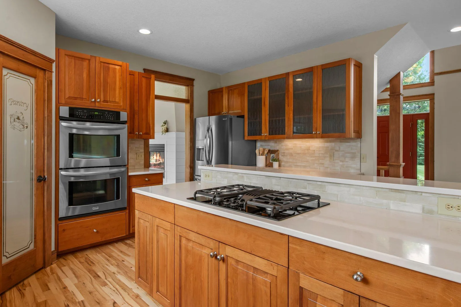 The gourmet kitchen includes custom cabinets, a double oven, cooktop and a stainless steel appliance package.