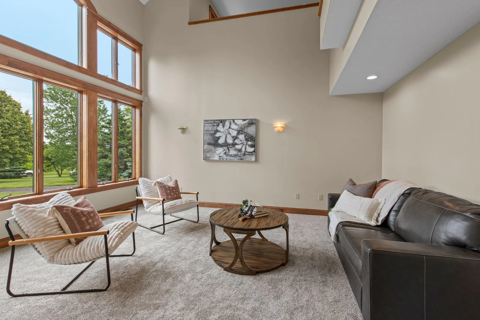 The living room features massive windows that allow lots of natural light in.