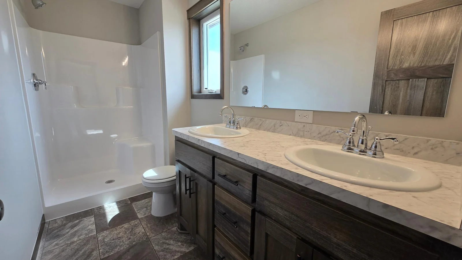 The primary 3/4 bath offers a double sink vanity, 3x4 fiberglass shower bay and a single casement window.
