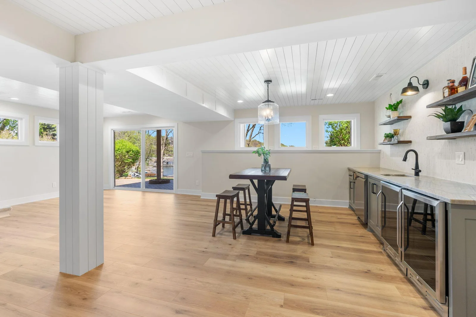 Oversized patio door offers access to the paver patio, property and lake!  Note: Soffit paneling in bar area is cork, display your favorite photos and decor!