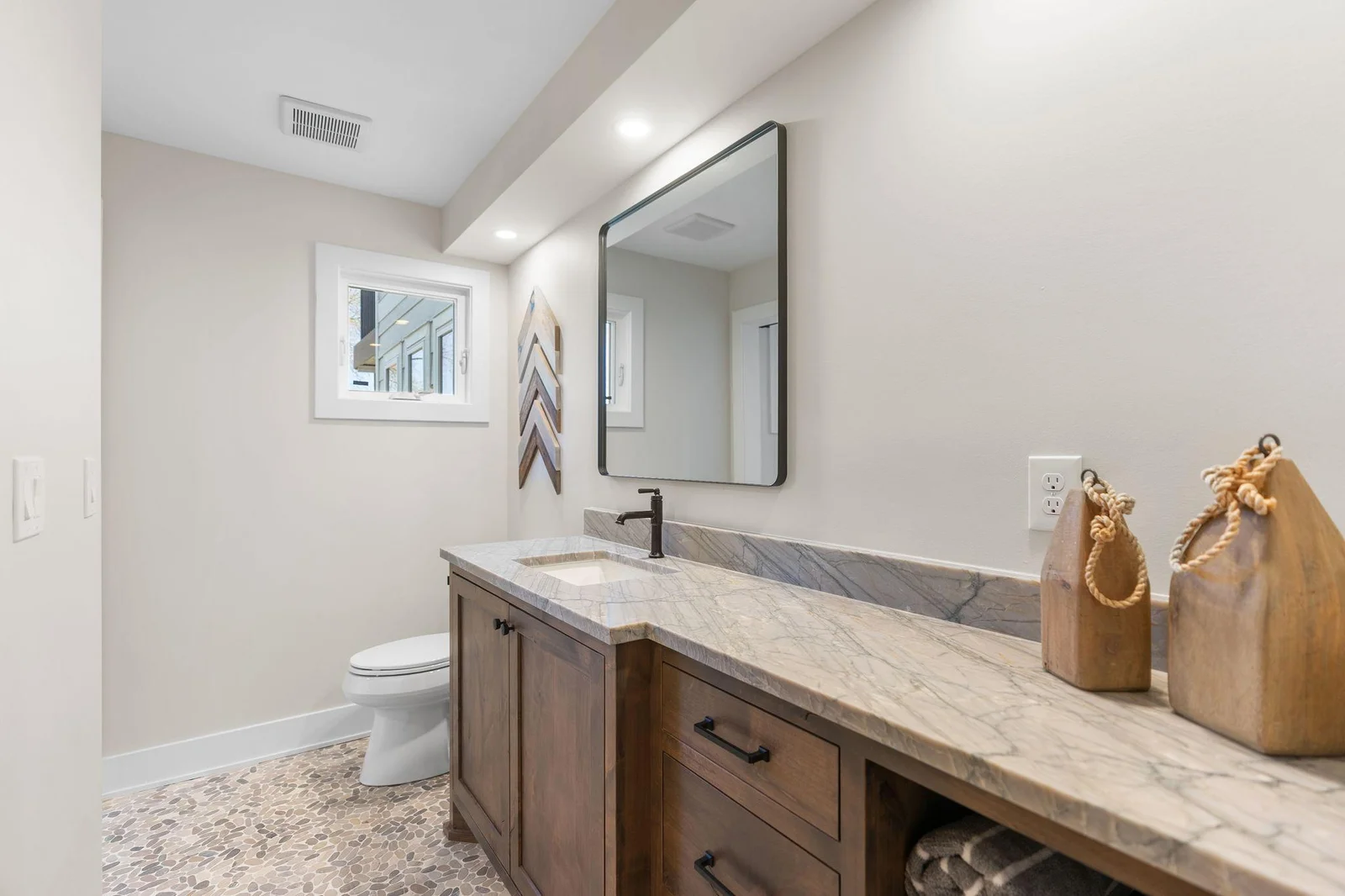 3/4 bathroom in the lower level features rustic alder vanity cabinet that offers storage, towel display and natural quartzite countertop