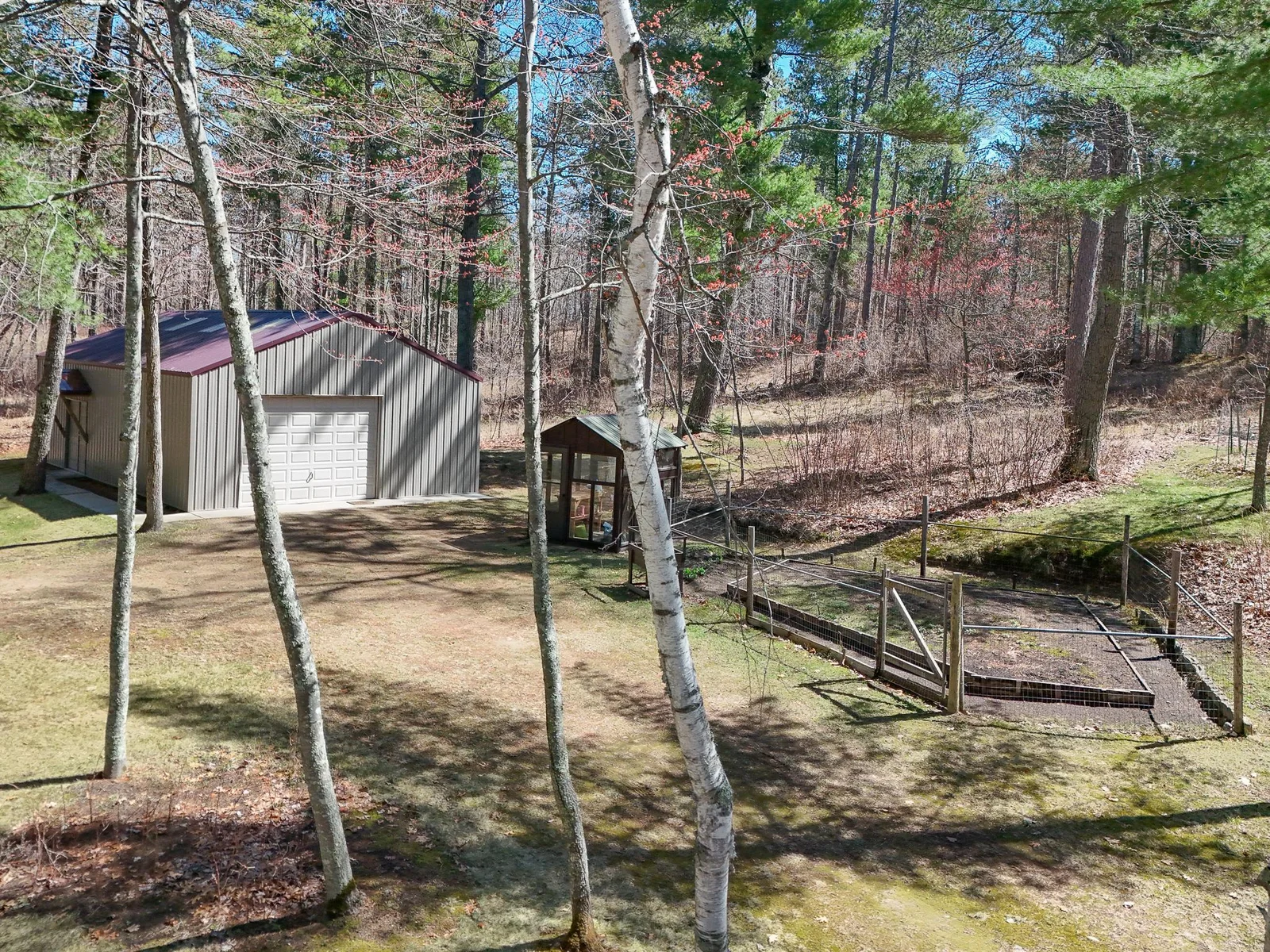 26x40 Pole Barn sits on an additional 2.77 acres directly across the road - garden shed and fenced in garden to the right