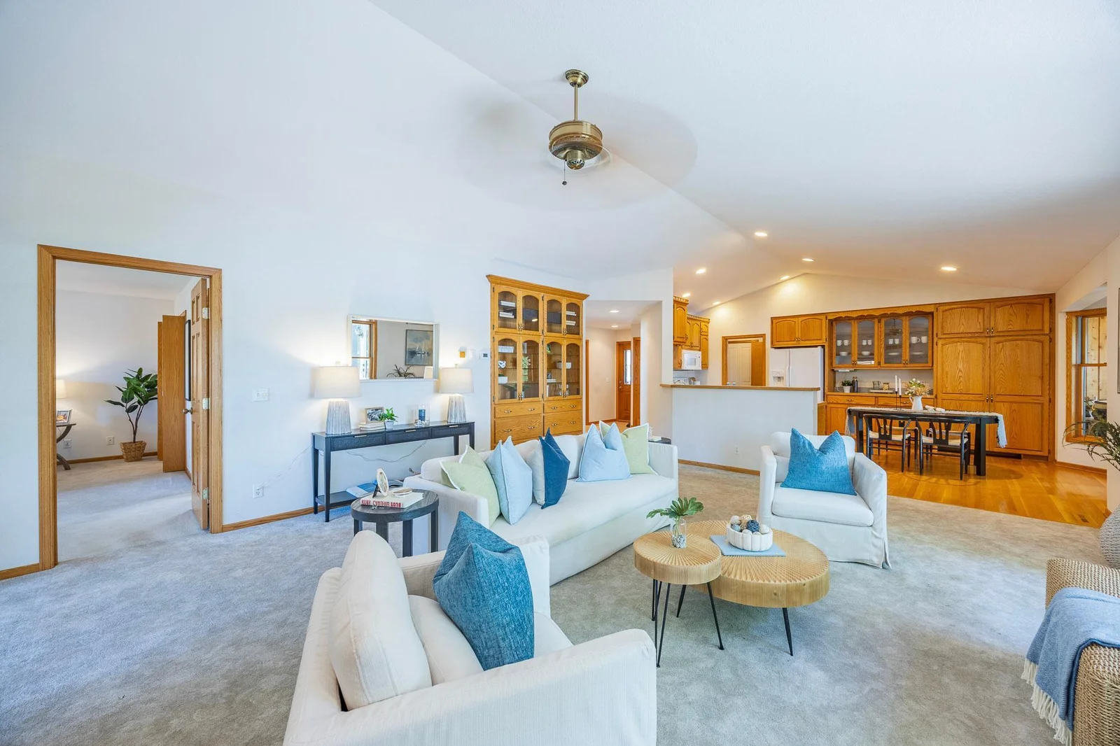 Vaulted ceilings create a sense of spaciousness, while large windows flood the space with natural light. The seamless flow between the living room, kitchen, and dining areas makes it perfect for entertaining or relaxed everyday living.