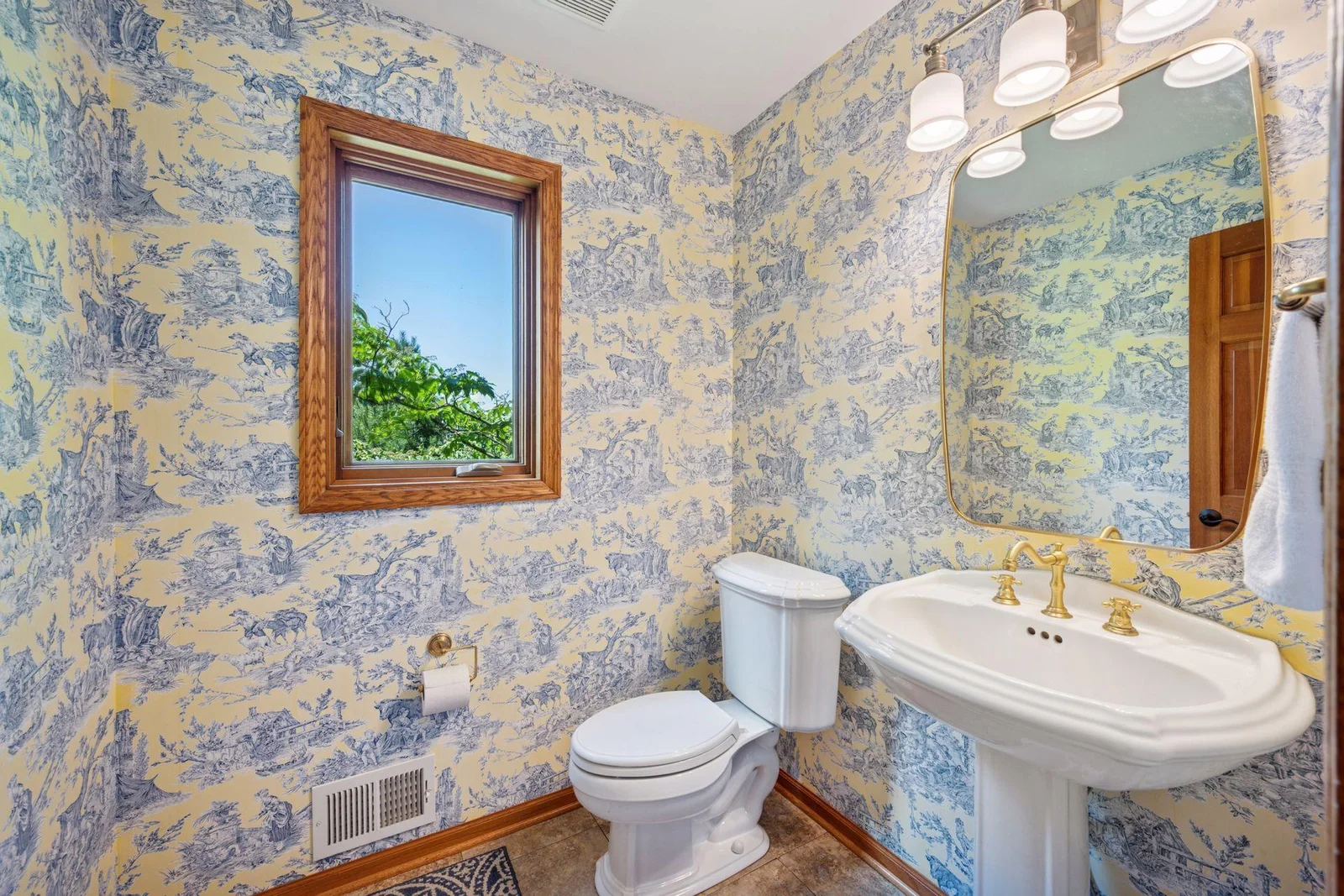 Powder room on main level features pedestal sink.