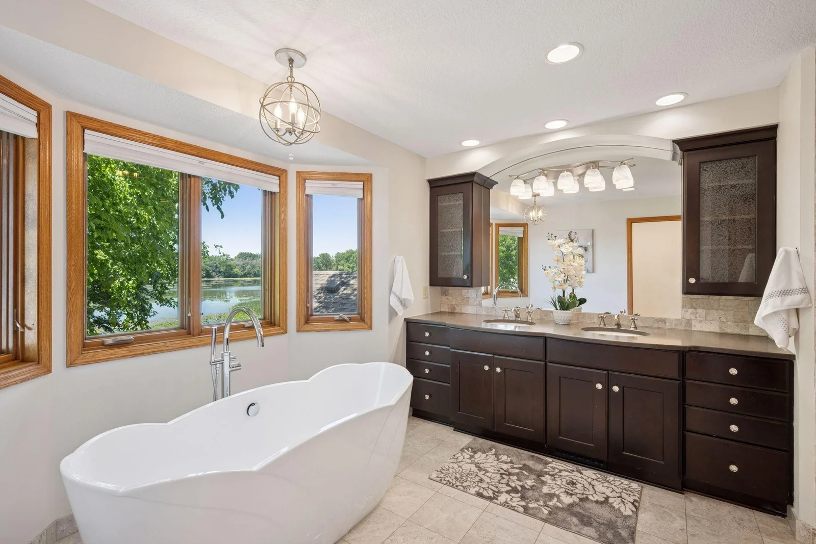 Primary suite bathroom feels like a spa!  Custom designed with recent updates include a large walk in shower, separate tub, double sinks and walk in closet.