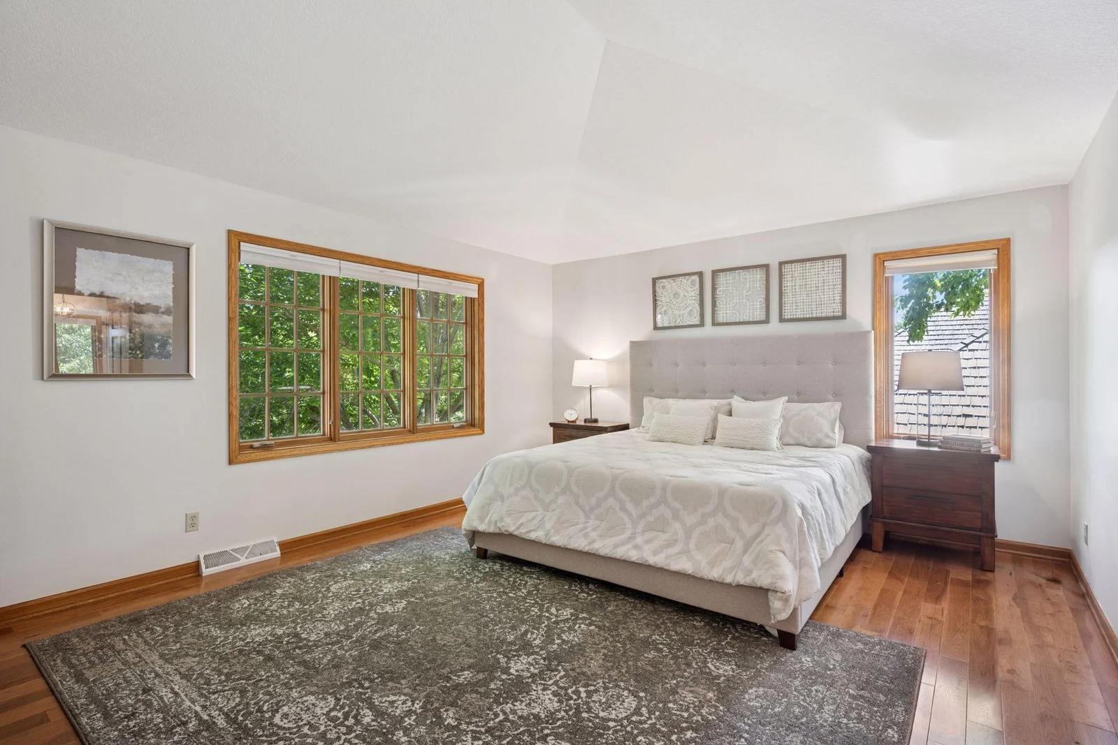 Primary suite features gleaming wood floors, vaulted ceiling and large spa like bathroom.