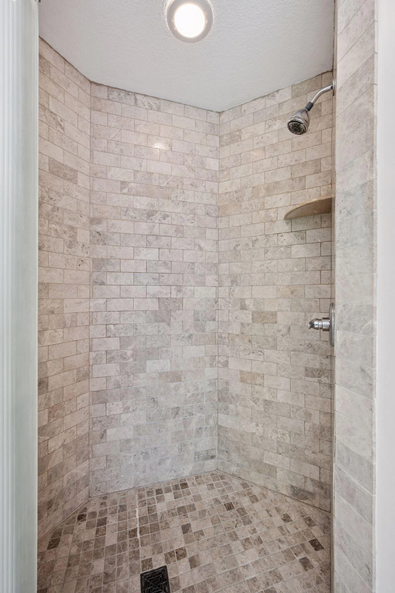 Walk in shower with tile surround in primary bathroom.