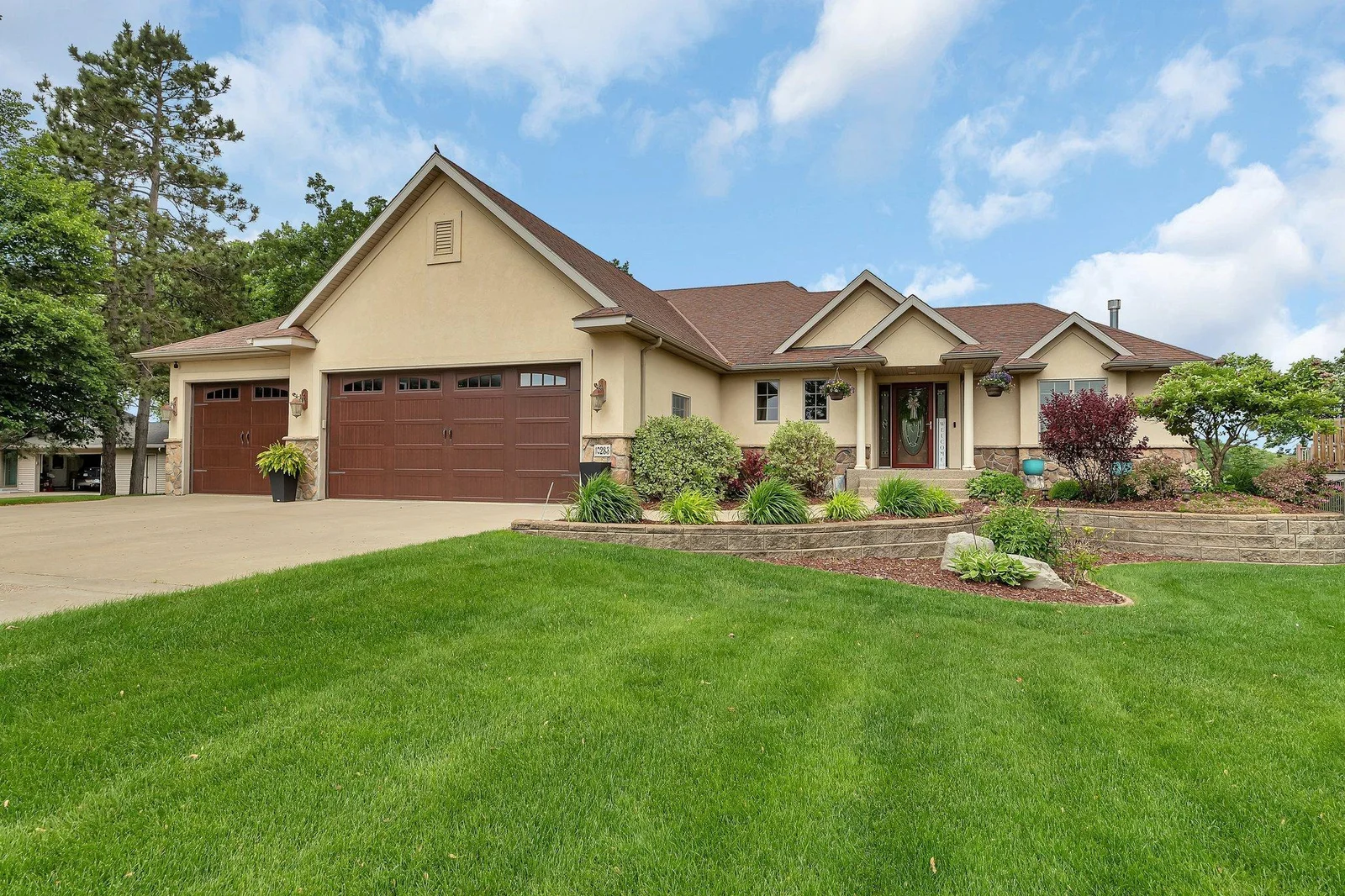 Beautiful curbside with mature landscape and concrete drive.