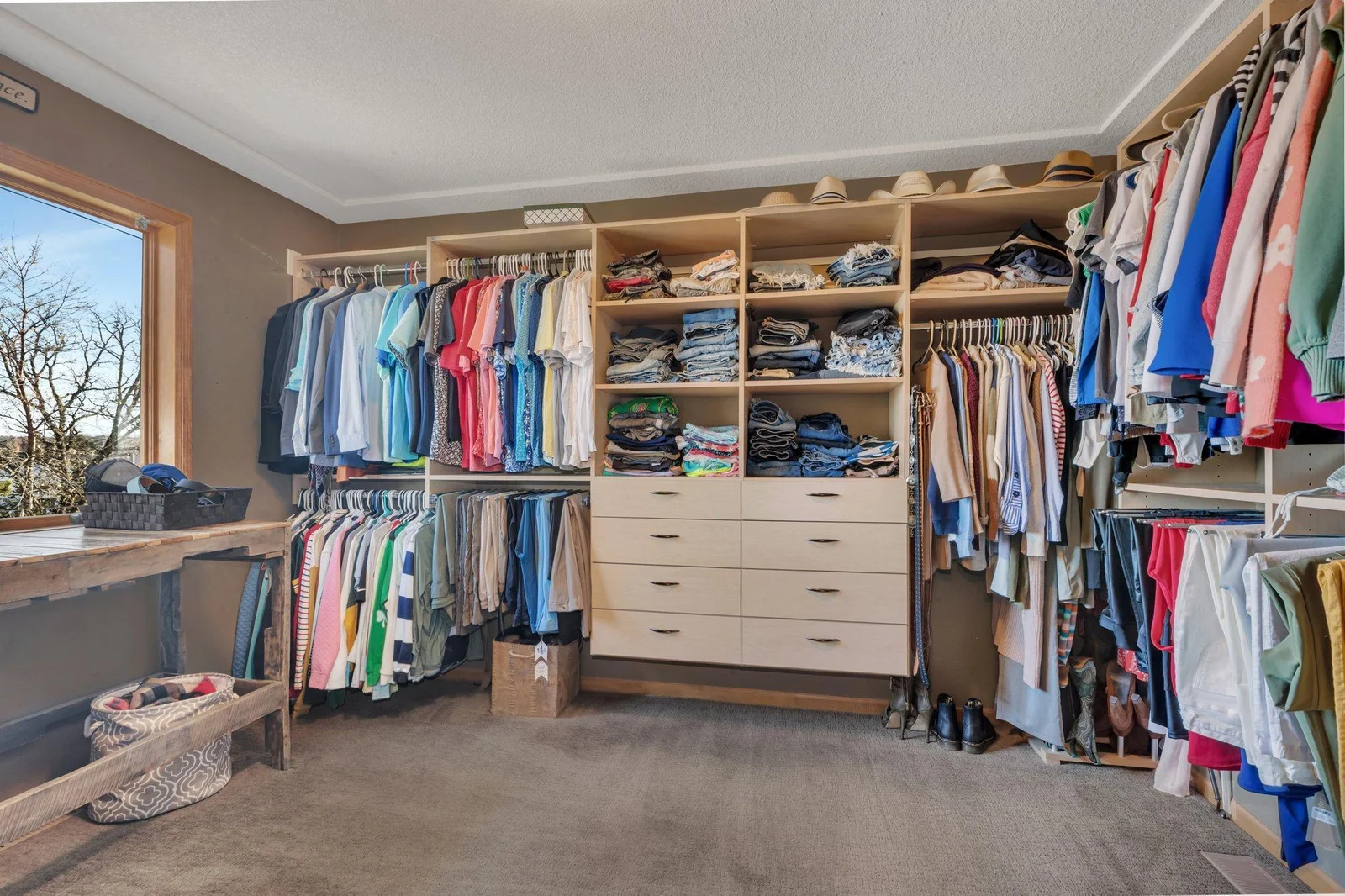 Expansive walk in closet with build in shelving and drawers.