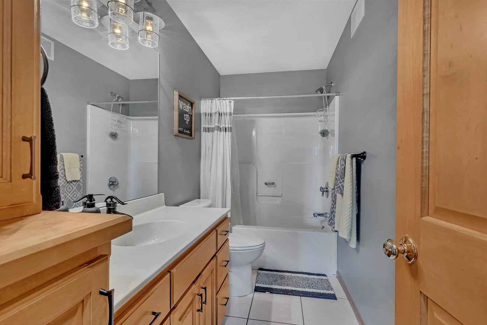 Full bathroom with nice color tones, storage space, and a large vanity.