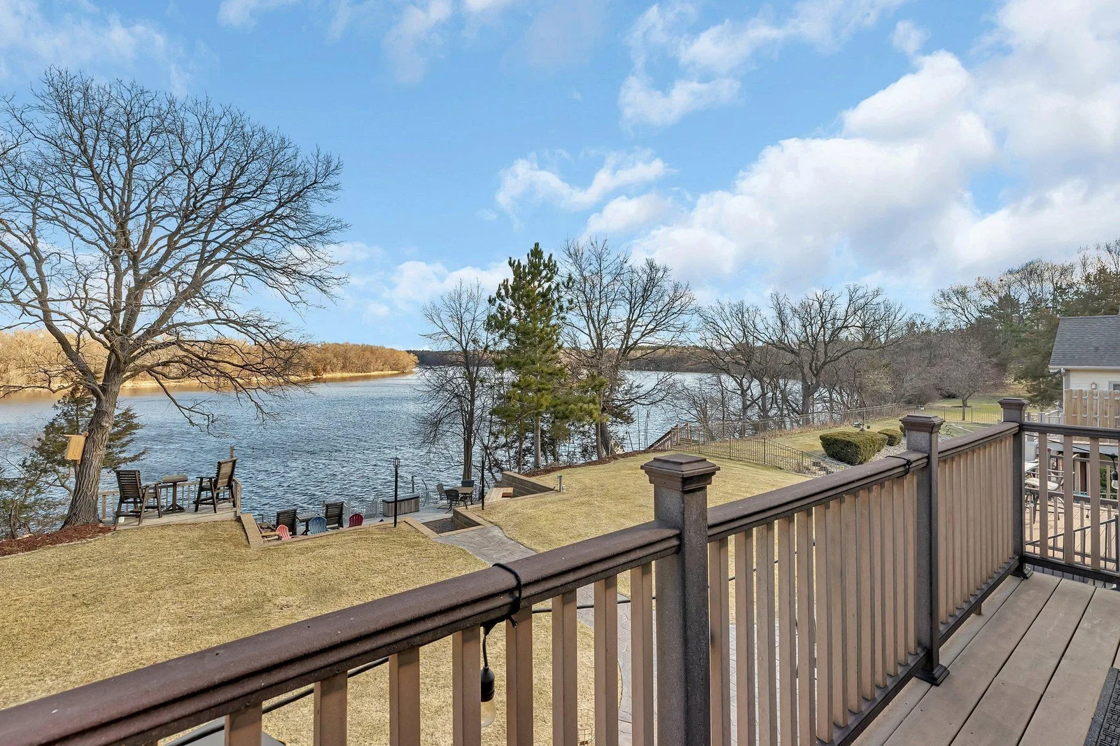 Primary balcony overlooks the river and sitting spaces in the backyard.