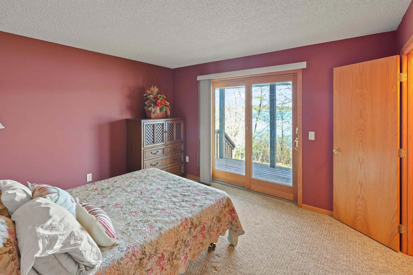 Primary bedroom with sliding door to lakeside covered porch