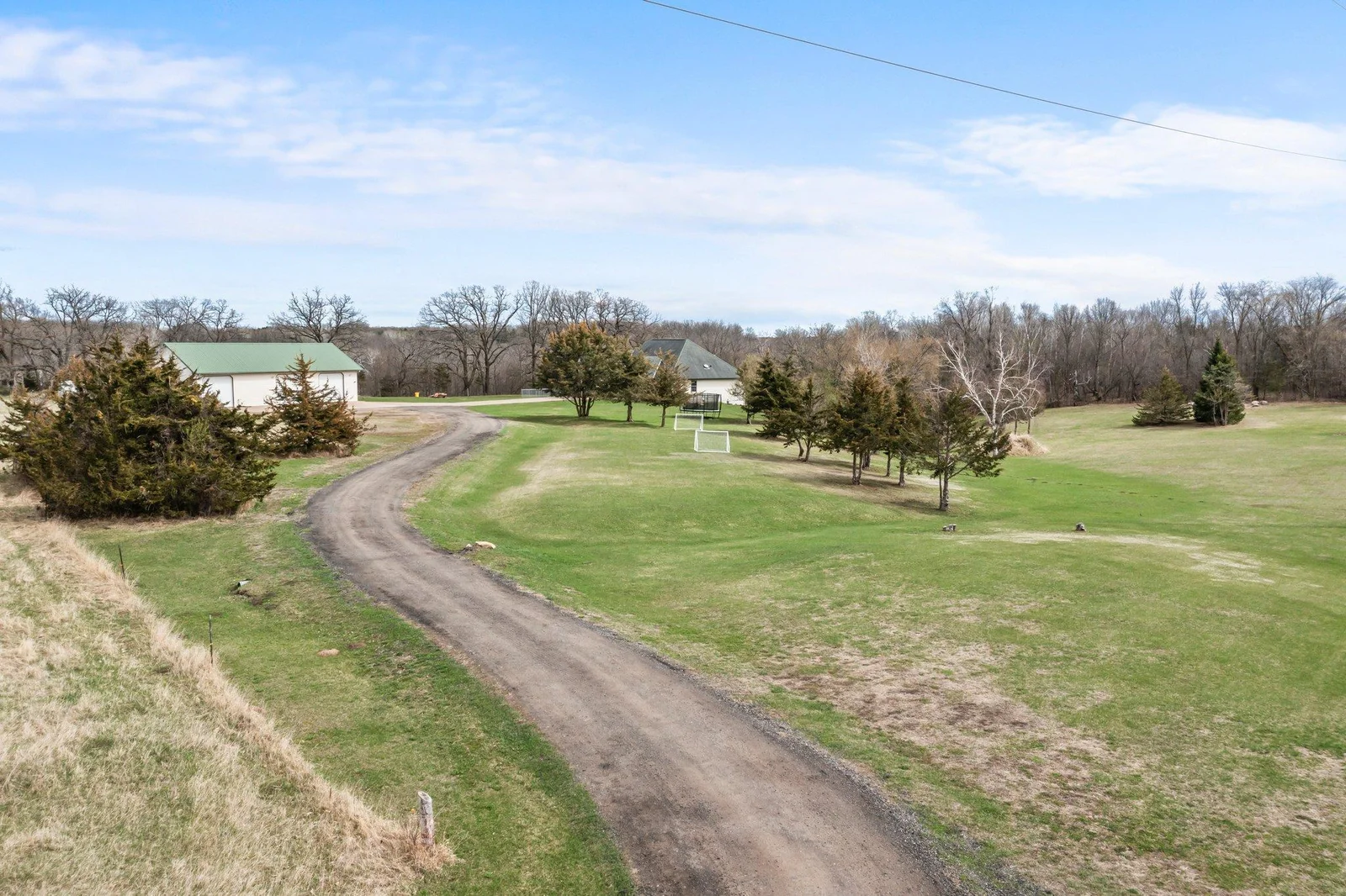 Long driveway that leads to concrete driveways that butt up to home & detached garage