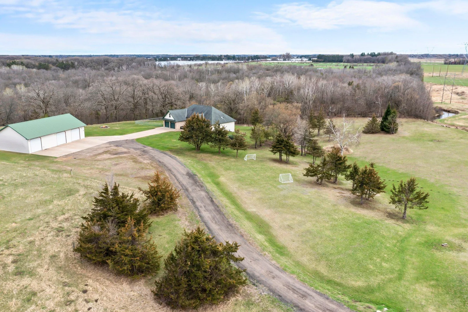 Long driveway that leads to concrete driveways that butt up to home & detached garage