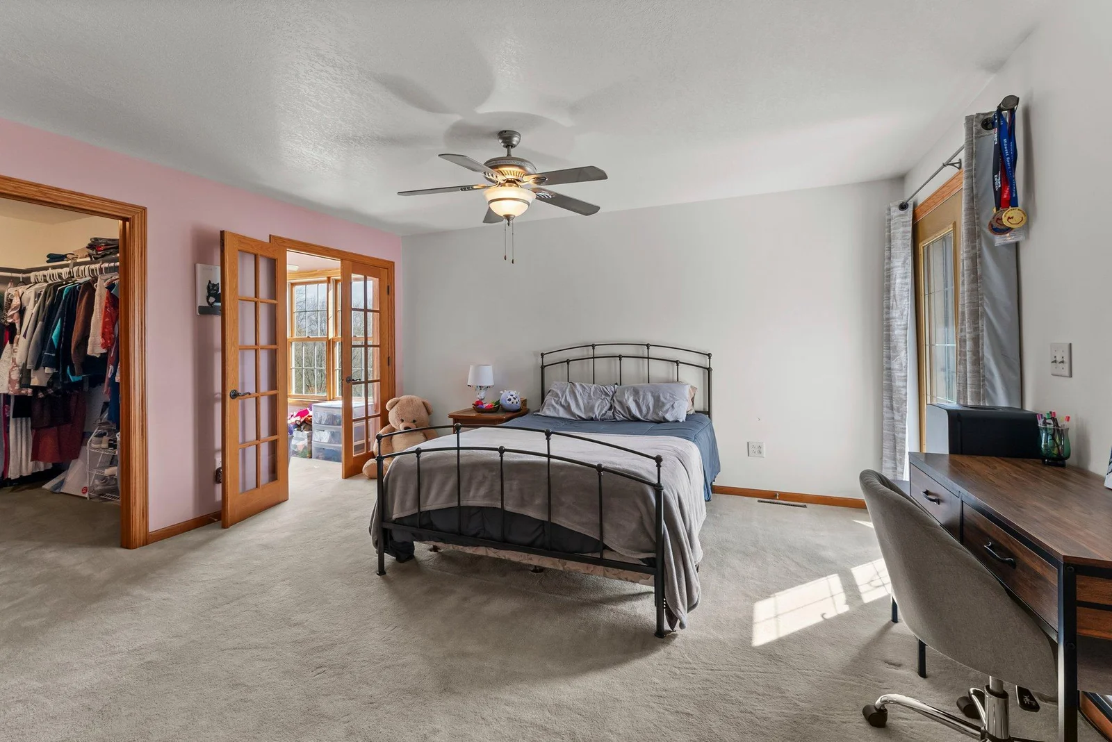 Main level First Primary Bedroom (aka, master bedroom). This view shows beautiful glass french doors leading to private sunroom.