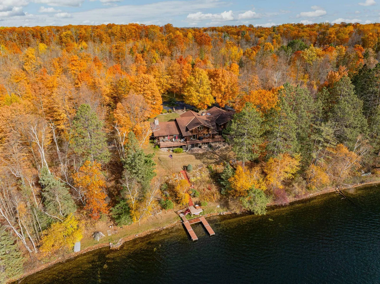 Propery features mature tress with vibrant colors in the fall