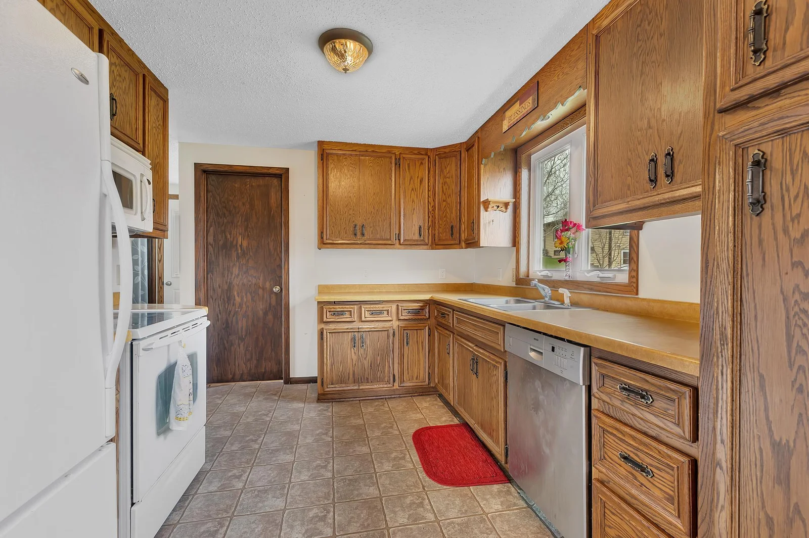 Inside, raised oak cabinetry anchors a warm and inviting kitchen, where all appliances are included.