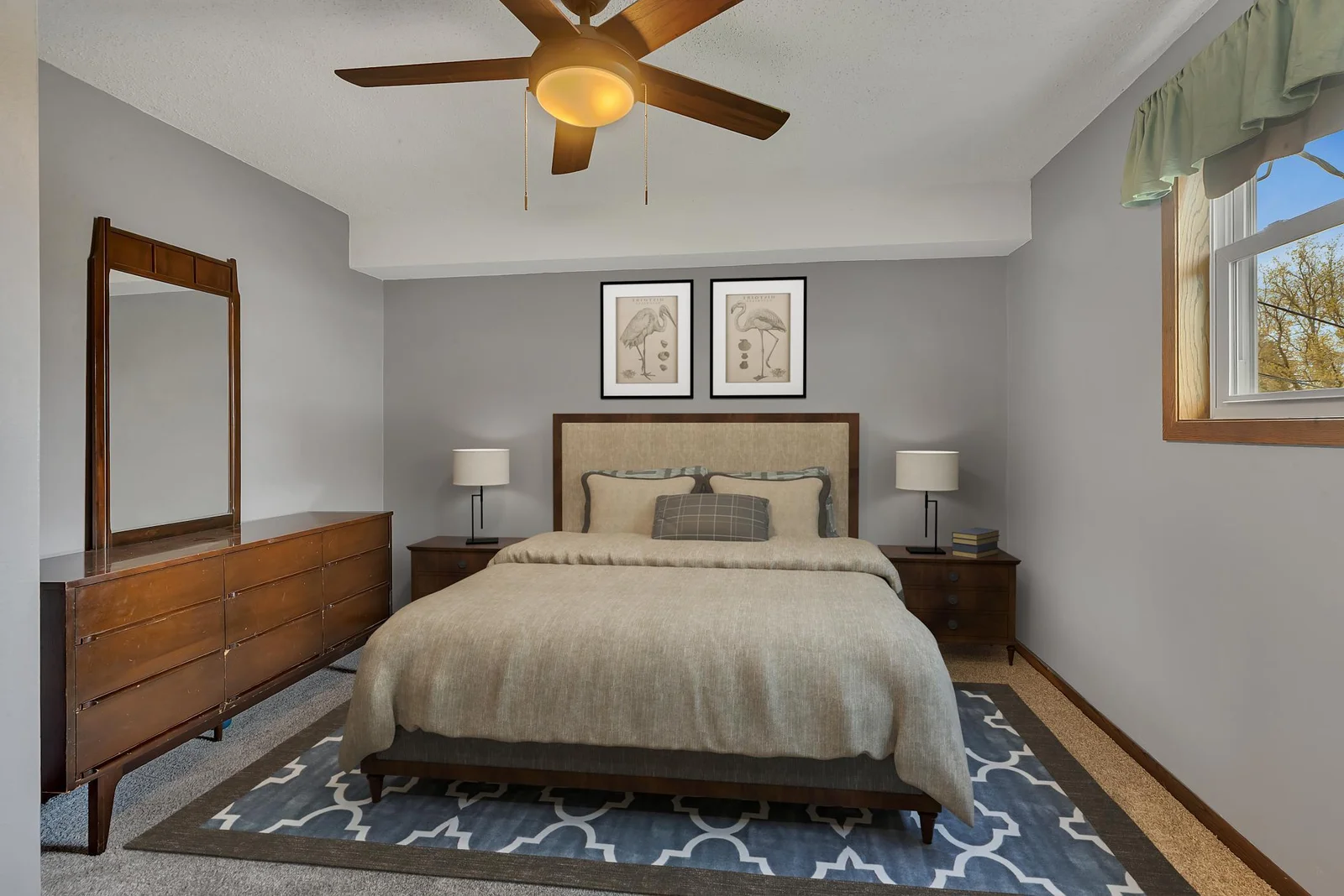 Main level primary bedroom with a ceiling fan and new carpet flooring.