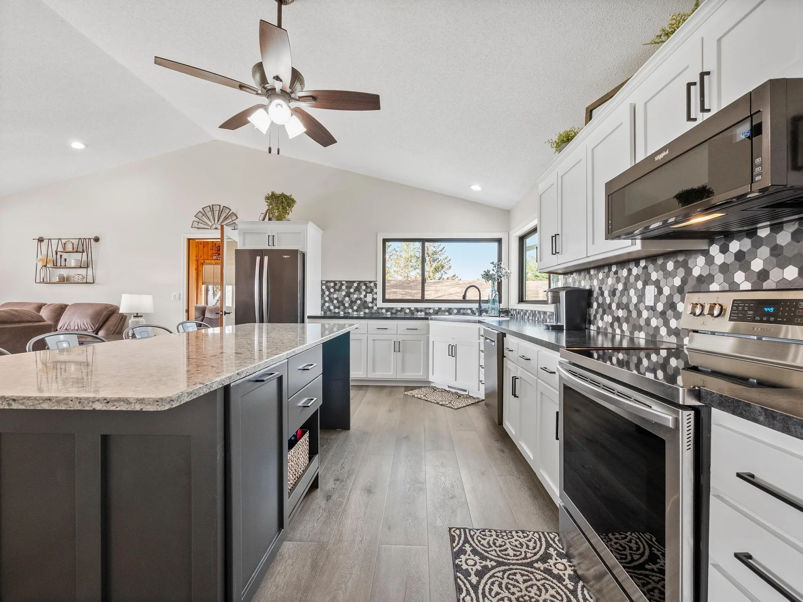 A close up view at the stunning kitchen showcases sleek new appliances, elegant countertops, and a hexagon tile backsplash that adds modern flair.
