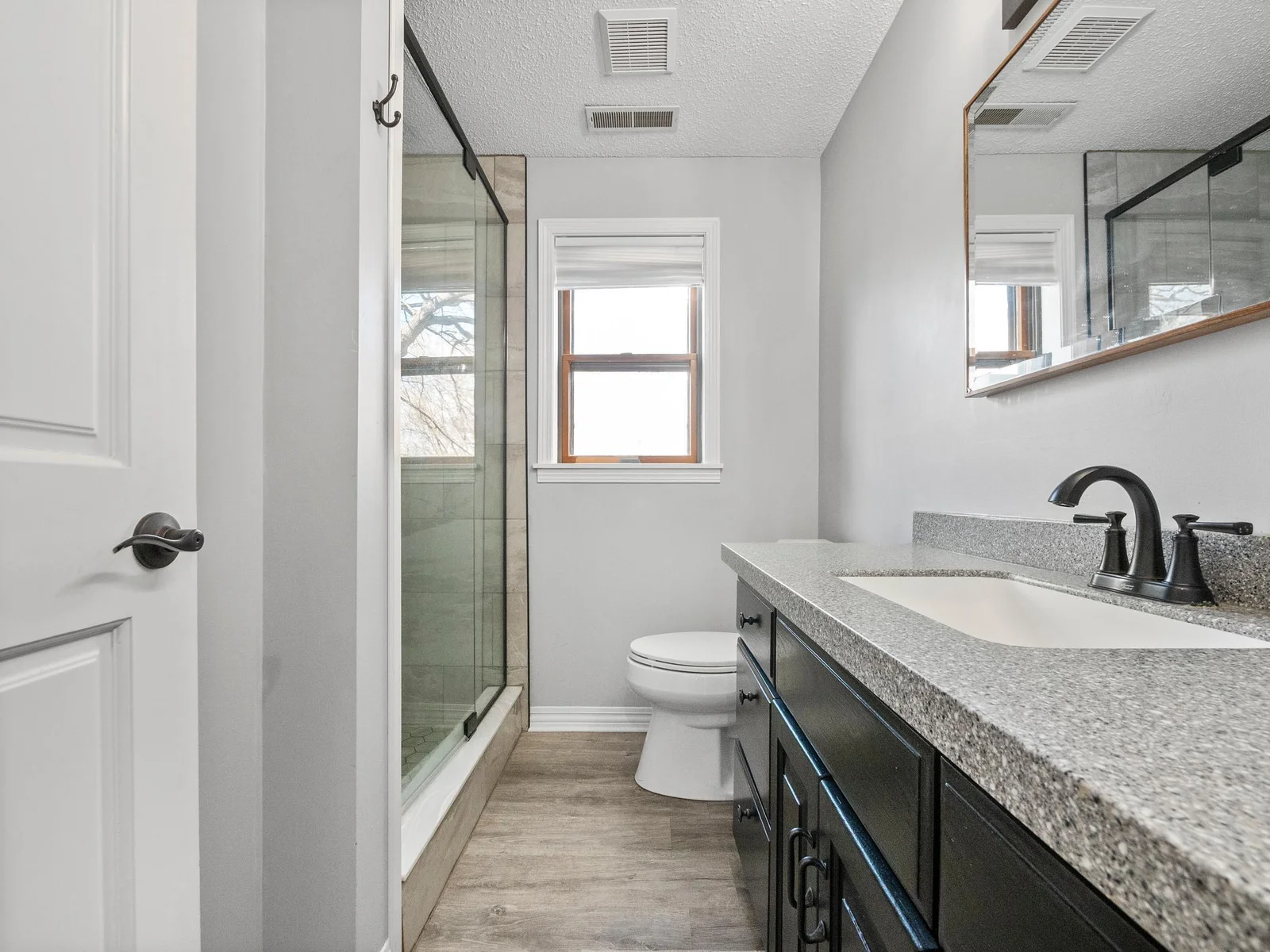 Newly added 3/4 bath featuring a walk-in shower with sleek glass sliding doors.