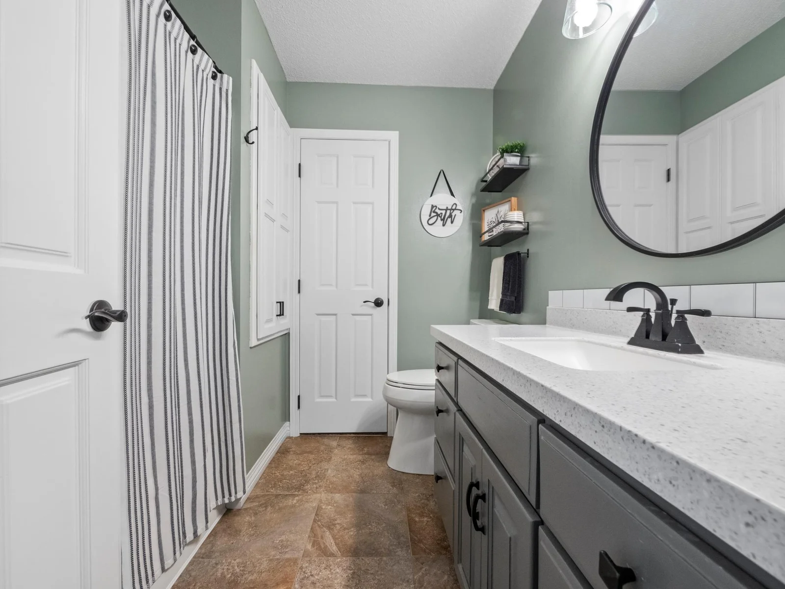 The main floor full bath with sleek vanity, hard surface counters, and stylish finishes. Ideal for guests and everyday use.