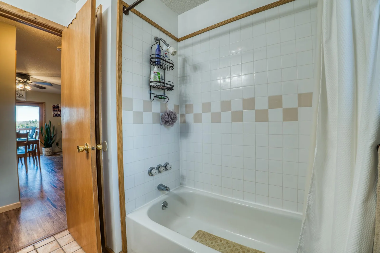Main floor full bathroom with tiled tub surround