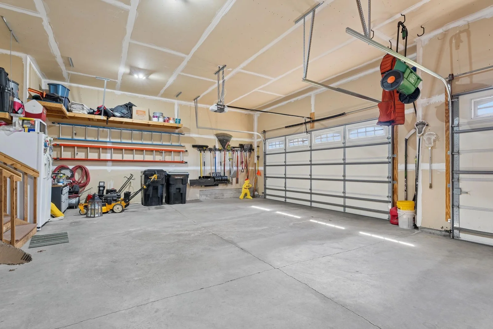 The fully sheet rocked three car attached garage has openers on both doors, 8' tall doors, extra built-in storage and is 26' deep!
