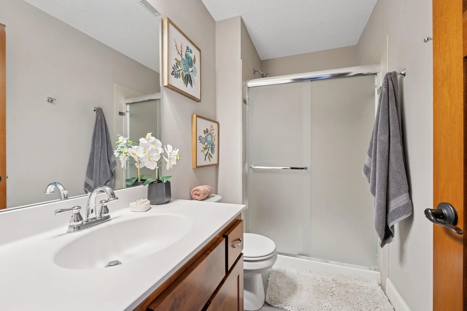 The 3/4 bath in the junior/princess suite bath features a tile shower surround with a glass door.