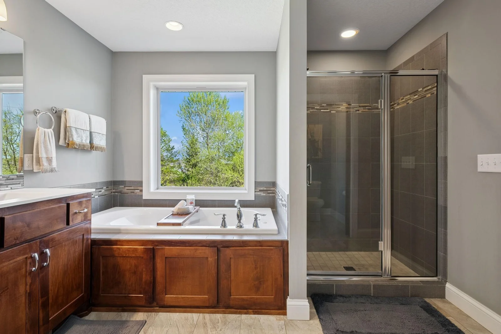 The tub being separate from the tiled walk-in shower allows one person to take a bath the other gets clean in the shower.