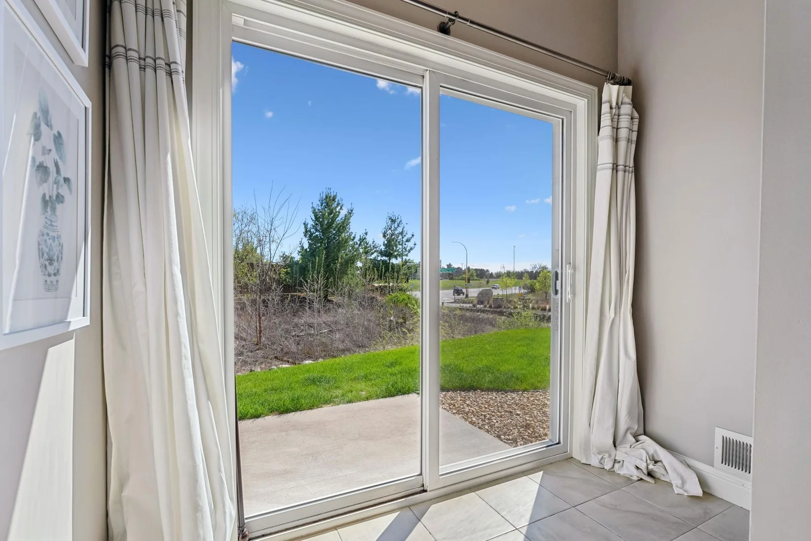 Halfway down the steps from the main level to the lower level, there is a landing with tile floors, walking out to the side yard. This is south facing too, ensuring a flood of natural light.