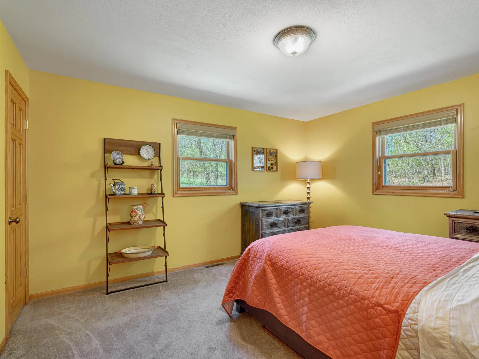 Main floor primary bedroom features two single hung windows allowing for peaceful green space views and plenty of fresh air.