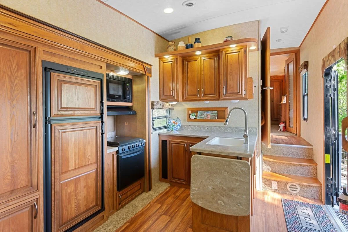 The galley kitchen features a handy countertop extension, paneled refrigerator and freezer and ample cabinet space.
