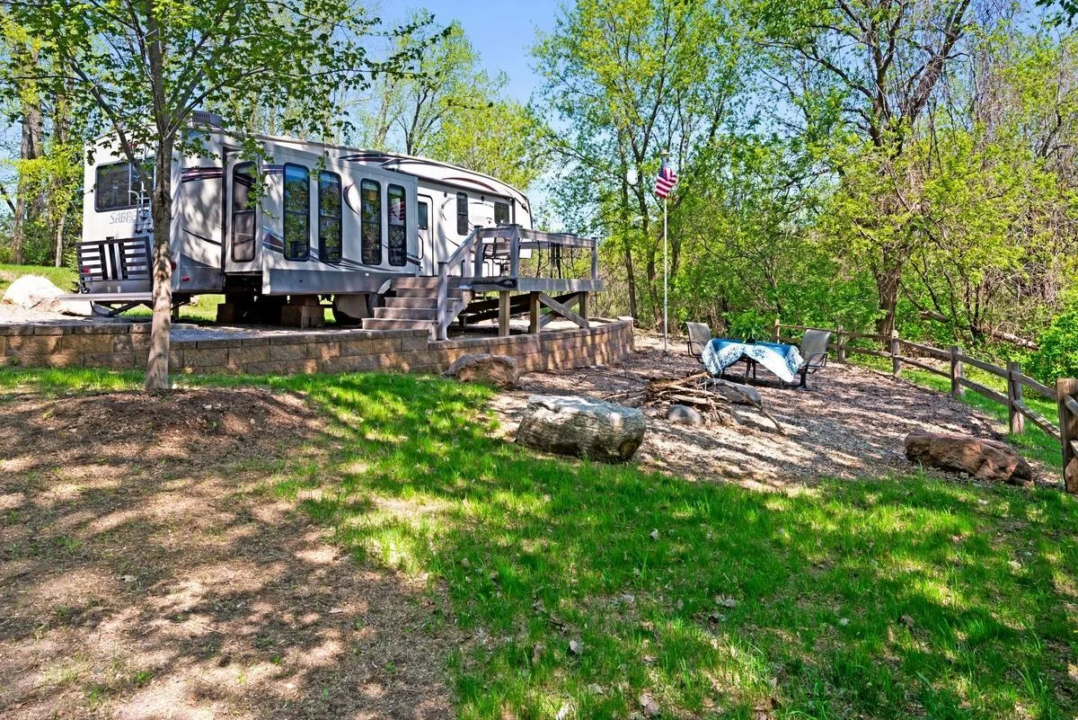 Enjoy the ultimate lakeside retreat with this thoughtfully landscaped outdoor space.  The gentle slope of the yard leads to a private seating area complete with natural stone accents and a cozy campfire setup.